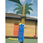 A playground weather station display shaped like a palm tree stands on rubber flooring with a brick building and toys in the background.