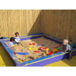 Children playing in a large sandbox