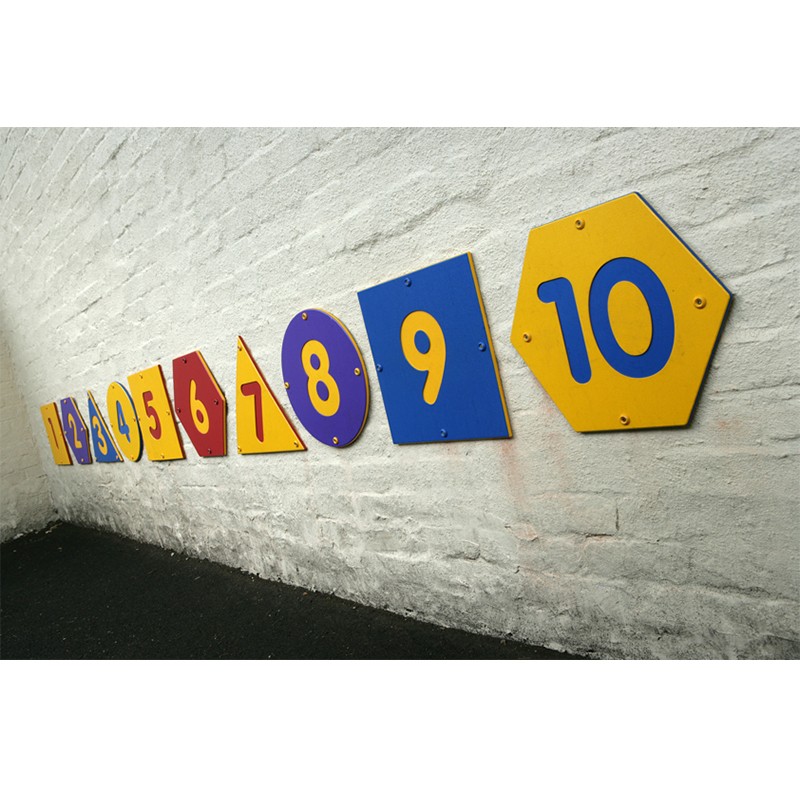 Ten colourful, numbered signs from 1 to 10 are mounted in sequence on a white brick wall along a tarmac surface.