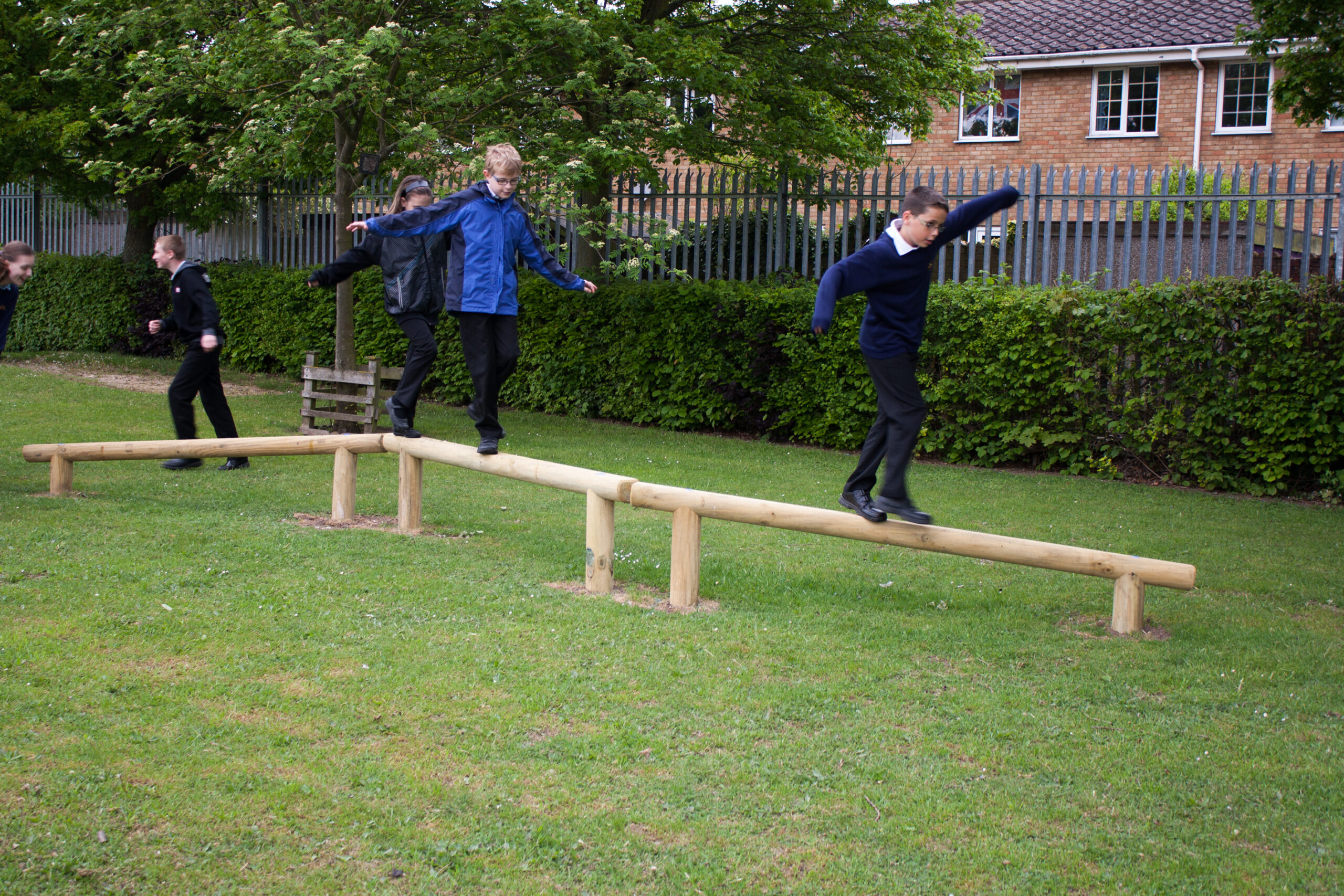 balance run with 3 children balancing. Balance beams set into grass