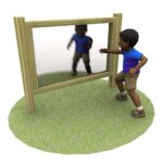 A child in shorts and a t-shirt stands on grass, reaching towards a large outdoor mirror framed with wood.