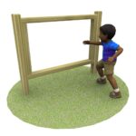 A child standing on grass, reaching towards a large wooden rectangular frame.