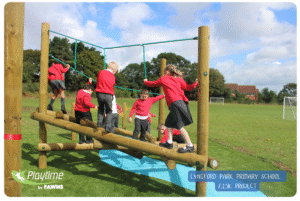 Lyngford Park Primary School outdoor play equipment. Timber pick up sticks with green ropes from Playtime by Fawns. Children in red jumpers climbing the equipment