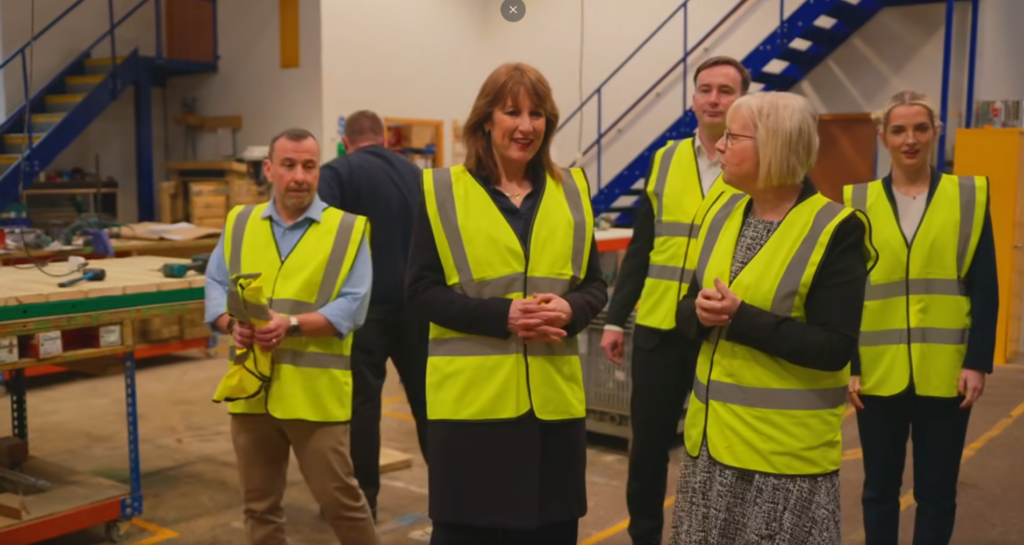 5 people in high vis jackets inside the Fawns workshop taking a look around