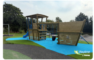 A wooden playground structure shaped like a ship with climbing nets, a slide, and safety flooring on a playground. The logo Playtime by FAWNS is visible in the bottom right corner.
