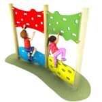Two children climb an adjoining jigsaw traverse playground wall with red, green, blue, and yellow panels on a grassy surface.