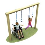 Two children, one in a wheelchair and one standing, play together on a swing set with hanging rings on a grassy patch.